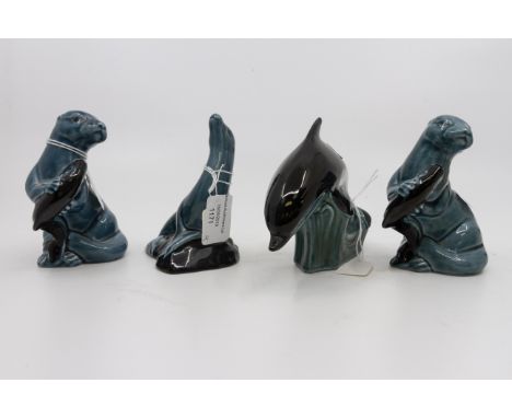 A collection of four Poole Pottery sea lions and dolphins
