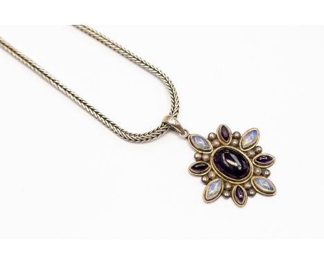 A moonstone and amethyst pendant, flower design set with an oval amethyst to the centre with a border of alternate marquise s