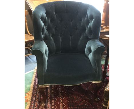 An early 20th Century blue upholstered deep button wing backed chair, traditionally upholstered, braiding to edges, standing 