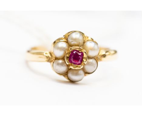 A ruby and seed pearly cluster ring, unmarked 9ct gold,  the central set ruby set within a border of pearls, size K1/2, total