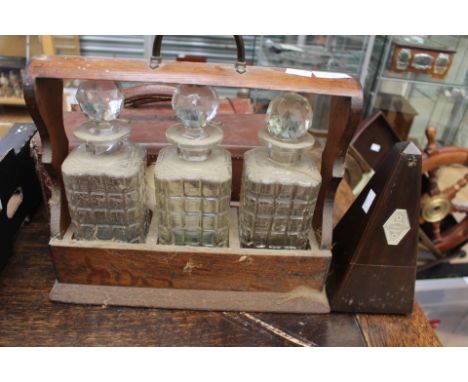 Mid 20th Century tantalus, three decanters with stoppers and key, along with a piano metronome 