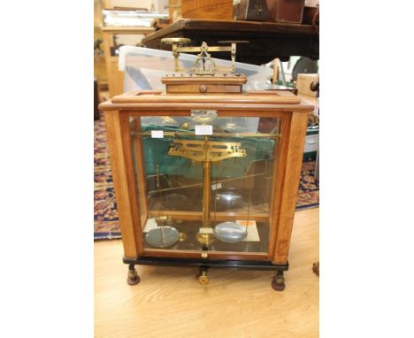 A 20th Century L. Gertling boxed set of postal scales, London, mahogany, the glazed case with a sash door, 51 cms high, 45 cm