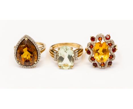 Three 9ct gold stone set dress rings, including a tear drop quartz with diamond surround version, size K, a citrine, garnet a