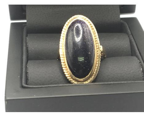 A 9carat gold ring set with a polished oval stone ring size O. Weight 6.4g