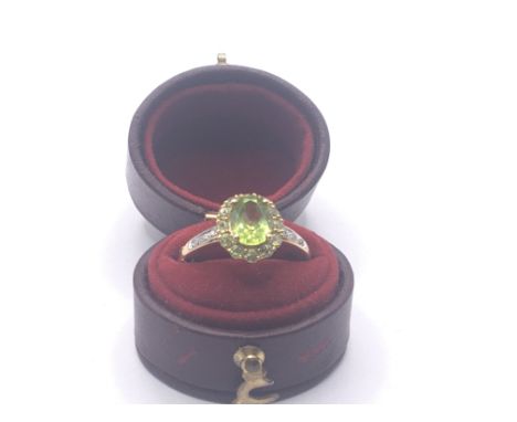 A 9carat gold ring set with a green tourmaline and chip diamonds in a fitted box. Ring size M.