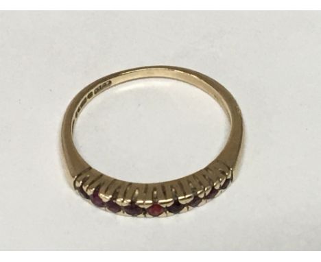 A 9carat gold half hoop eternity ring set with a row of ruby ring size N.
