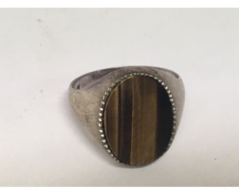 A silver ring set with an oval tigers eye stone. Ring size V.