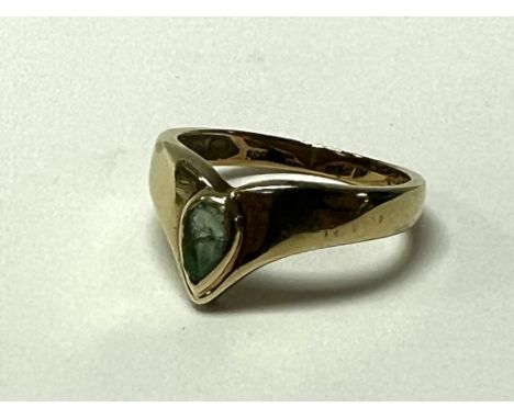 A 14K gold and teardrop shaped emerald ring, Size M. (A).