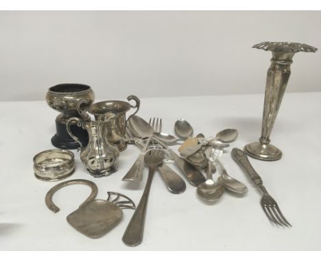 A collection of silver cutlery small silver trophies a silver caddy spoon and other ornaments.
