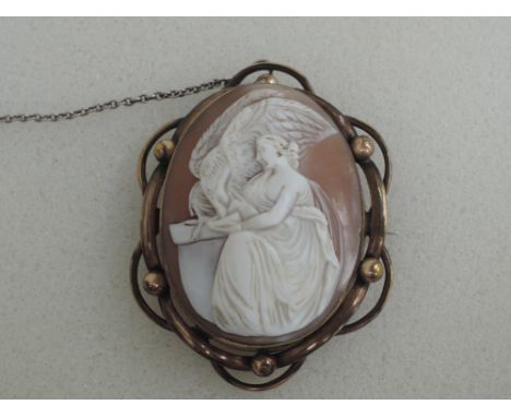 A Victorian conche shell cameo brooch depicting Hebe feeding the eagle of Zeus in a decorative pinchbeck surround