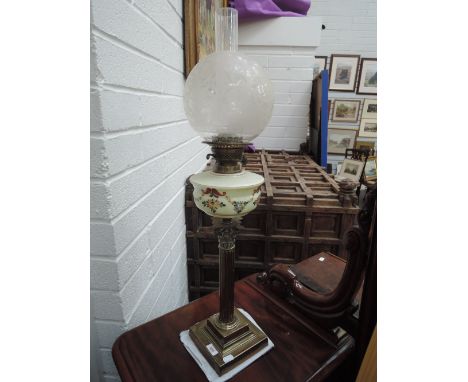 An Edwardian oil lamp having etched shade, with painted glass reservoir on brass corinthian column stand
