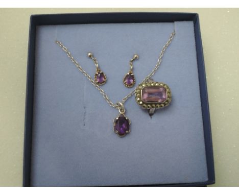 A white metal and amethyst set stamped silver consisting of pendant, earrings and ring