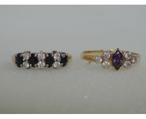 A ladies dress ring having a central lozenge shaped amethyst flanked by cubic zirconia to shoulders on a yellow metal loop st