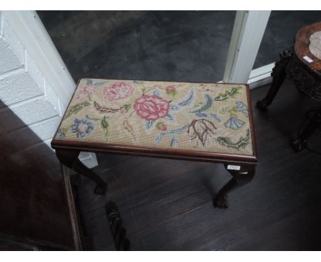 An early 20th century dressing stool having floral tapestry top, on cabriole legs and claw and ball feet