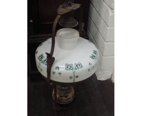 An early 20th century oil lamp of gimble design having Art Nouveau shade on embossed brass reservoir