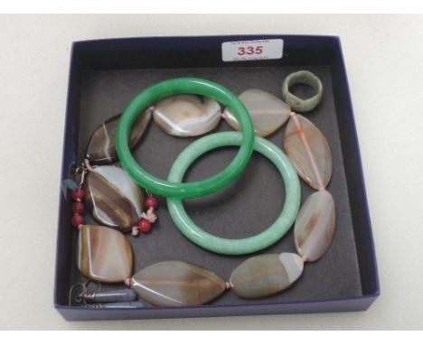 Two jade bangles, a carved jade ring, agate bead necklace and a pair of blue agate drop earrings