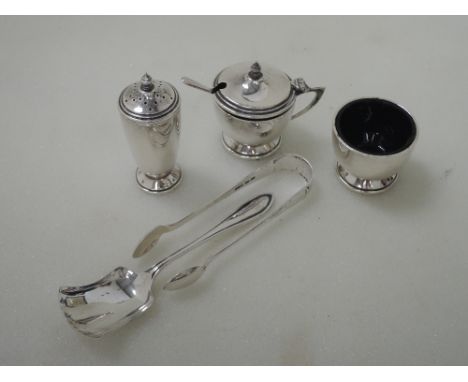 A three piece silver cruet set of plain form having reeded decoration and blue glass liners (matched EPNS spoon), Birmingham 