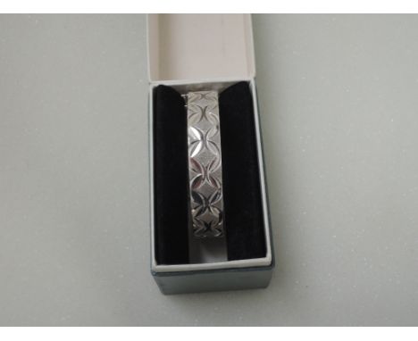 An HM silver hinged bangle having extensive engraved decoration