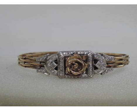 A yellow metal woven wire bangle having moulded rose and diamond decoration and barrel clasp, no marks