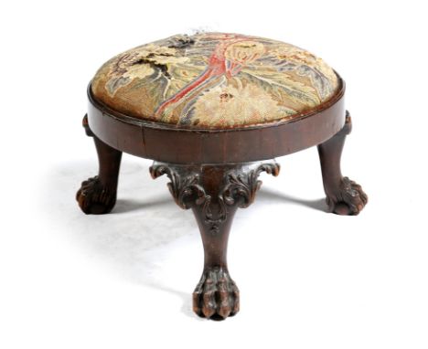 A mahogany circular stool, with a needlework seat worked with a parrot, on leaf carved tripod cabriole legs and hairy paw fee