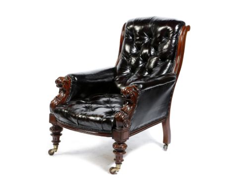 An early Victorian mahogany library armchair, button upholstered with black leather, on ceramic castors.
