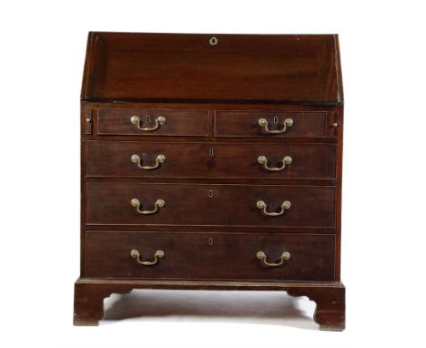 A George III mahogany bureau, the interior with an arrangement of pigeonholes and drawers, around a central pull-out cupboard