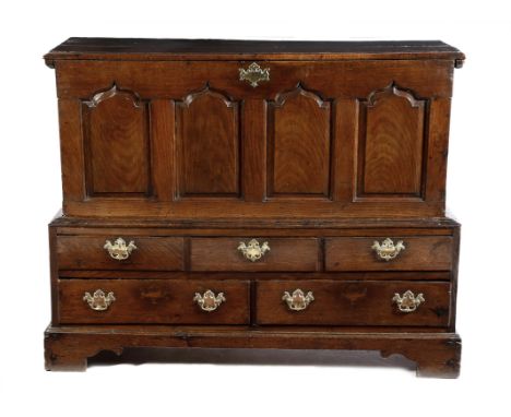 A mid-18th century Welsh oak mule chest, with a hinged top above a  quadruple fielded panel front, the base with five drawers