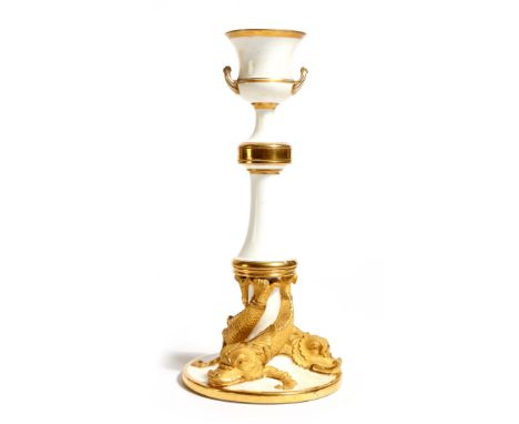 An early 19th century porcelain candlestick, white glazed with gilt decoration, with a campana shape urn sconce, the base wit