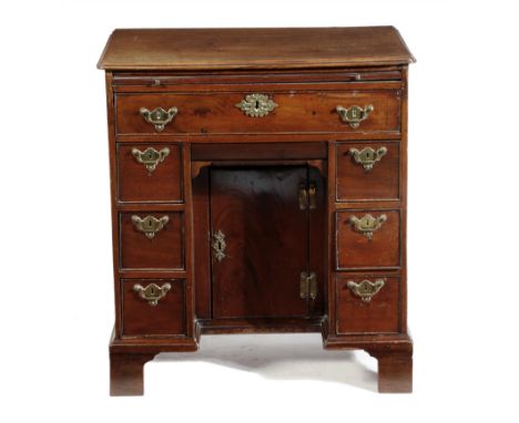 An early George III mahogany kneehole desk, fitted with a plush lined brushing slide, above an arrangement of eight drawers, 