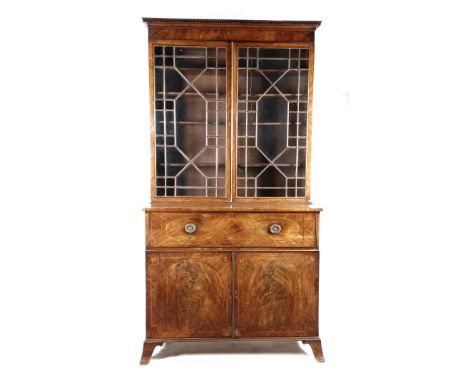 A mahogany secretaire cabinet, with a pair of geometric astragal glazed doors enclosing ten adjustable shelves, the base inla