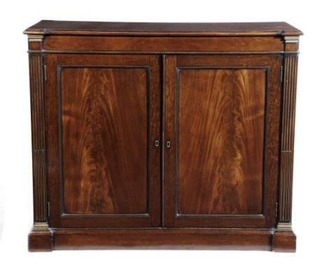 A pair of mahogany and brass mounted side cabinets, each with a moulded inverted breakfront top, above a pair of panelled doo