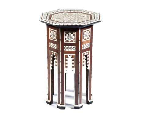 A Moorish hardwood octagonal occasional table, inlaid with mother of pearl with geometric decoration, and on mihrab arch legs