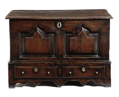 A Welsh oak coffer bach, the loose top above a vacant interior and a twin panelled front, the base with a pair of drawers, ab