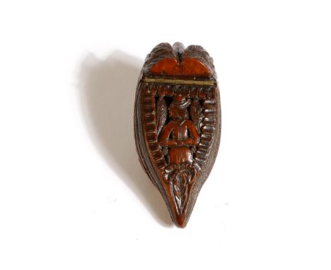 An early 19th century French carved coquilla nut snuff box, in the form of a shoe, the pierced hinged lid carved with an Indi