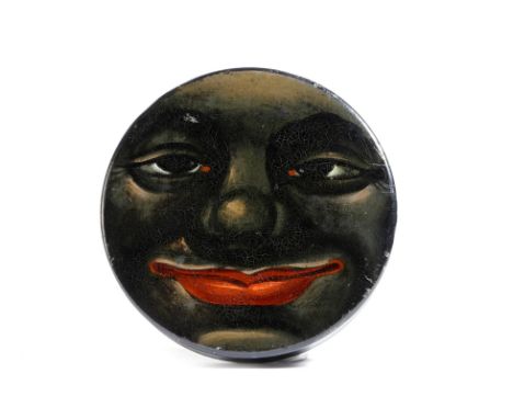A 19th century lacquered papier-mâché snuff box, of circular form, the lid painted with the caricature of the face of an Afri