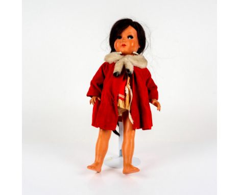 A ball-jointed doll with long braided brunette-hair; dressed in a red coat with white wool-style collar. Tiny Chatty Baby Dol