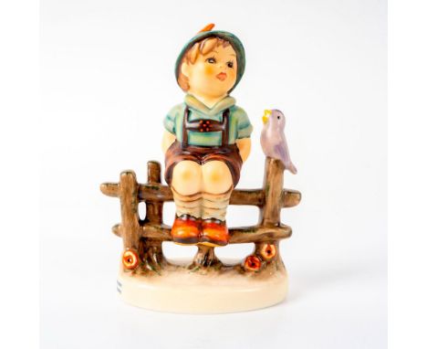 Figure of a boy dressed in lederhosen seated on a fence with bird alongside. This item has its original box. Box measures: 3.