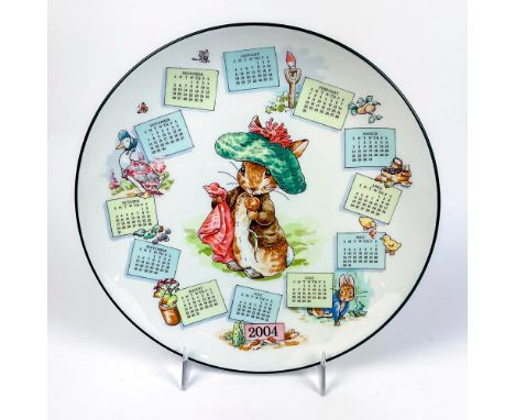 Collectors plate with an illustration of Benjamin Bunny in center with red handkerchief and calendar on surface with the year