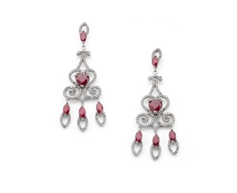 A pair of ruby and diamond pendant earrings Of chandelier design, each pear-shaped ruby centre within a scrolling openwork su