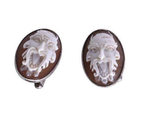 A pair of shell cameo cufflinks, the oval shell cameos carved with grotesque masks, to silver coloured closed back settings s