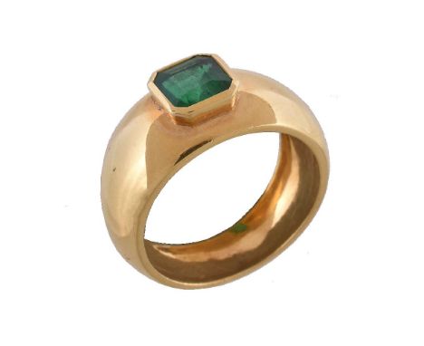 An emerald ring, the square cut emerald collet set on a wide band, stamped 750, finger size K 1/2, 5.8g Please note: The squa