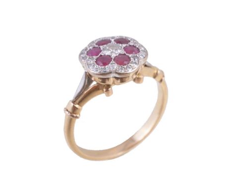 A ruby and diamond cluster ring, the central brilliant cut diamond,estimated to weigh 0.10 carats, within a surround of circu