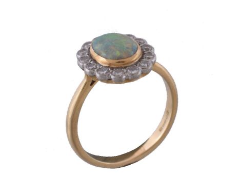 An 18 carat gold opal and diamond cluster ring, the oval cabochon opal within a surround of brilliant cut diamonds, approxima