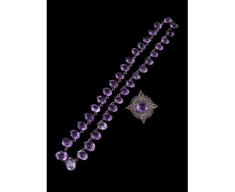 A mid 20th century amethyst riviere necklace, the graduated oval facetted amethysts within four claw settings, to a concealed