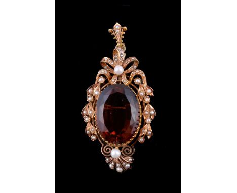 An early 20th century citrine, cultured pearl and seed pearl pendant/brooch, the oval cut citrine within a scroll and ribbon 