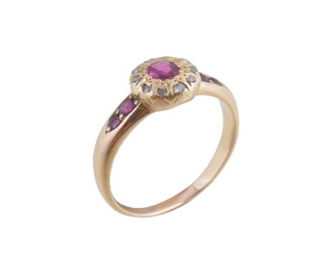 An early 20th century ruby and diamond cluster ring, the central oval cut ruby within a surround of rose cut diamonds, finger