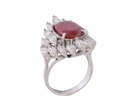 A ruby and diamond ring, the central oval cut ruby claw set within a surround of marquise cut diamonds, approximately 3.60 ca