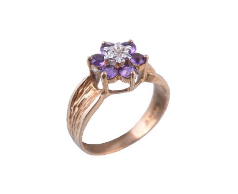 A 9 carat gold amethyst and diamond cluster ring, the central brilliant cut diamond within a surround of circular cut amethys