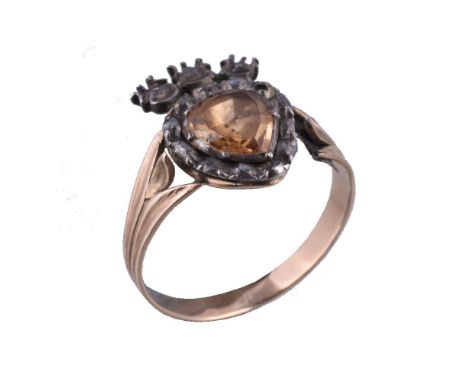 A topaz and diamond antique ring, the heart shaped panel with a foil backed pear cut topaz within a surround of lasque cut di