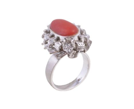 ϒA coral ring, the oval cabochon coral within a textured surround, stamped 18k, finger size M ϒ Indicates that this lot may b